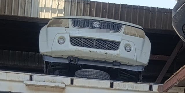 White Suzuki Grand Vitara front halfcut on a rack, with bumper, grille, headlights and fog lights, Sharjah market