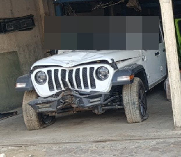 White Jeep Wrangler car for parts — damaged hood, grille, round headlights and fender flares, Sharjah market