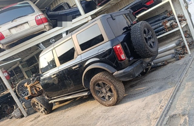 Black Ford Bronco SUV for parts, front end removed — doors, tailgate, spare wheel, Sharjah market