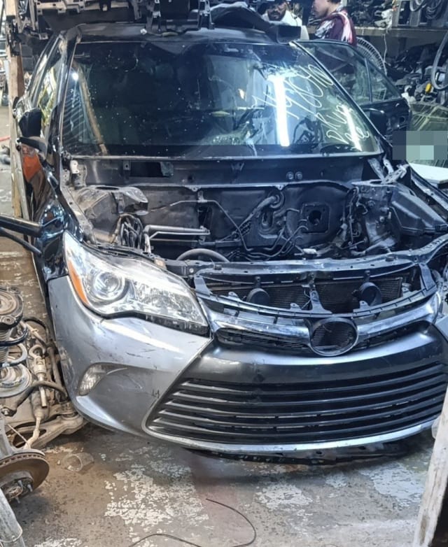 Grey Toyota Camry halfcut front — bumper, grille, headlight and empty engine bay, Sharjah market
