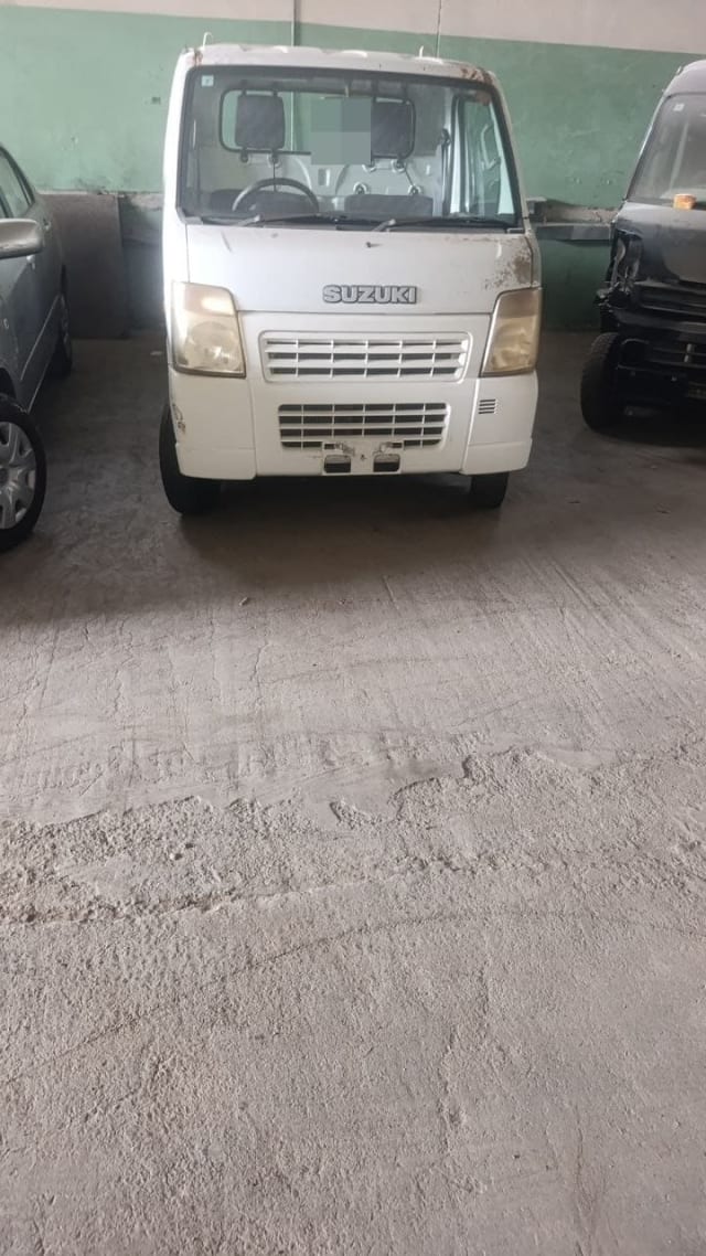 White Suzuki Carry kei truck for parts, front view with headlights, grille and bumper, Sharjah market