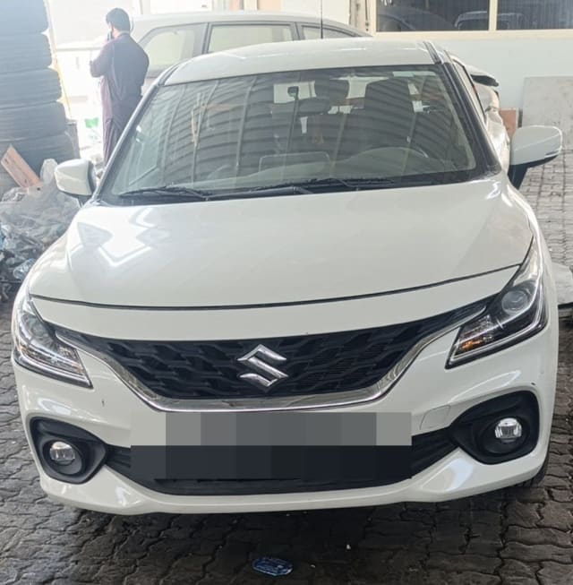 White Suzuki Baleno hatchback front view — bumper, grille, headlights and hood, Sharjah market