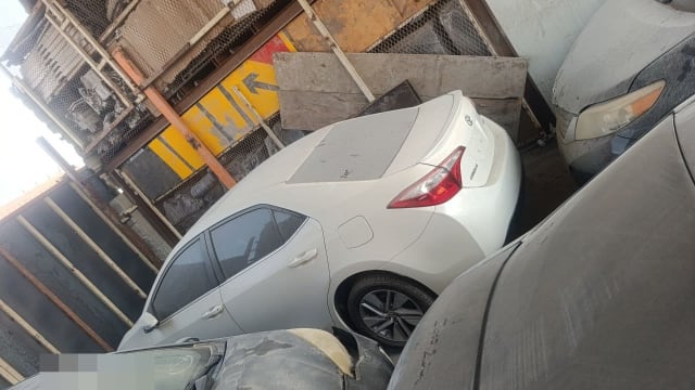 White Toyota Corolla sedan for parts — trunk, tail light, doors and alloy wheel, Sharjah market