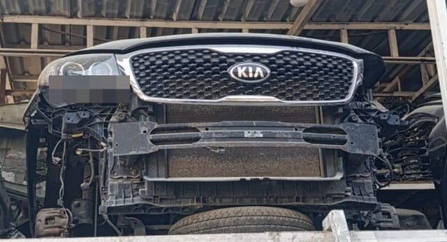 Black Kia Sorento front halfcut: grille, hood, headlight, radiator and bumper bar, Sharjah market