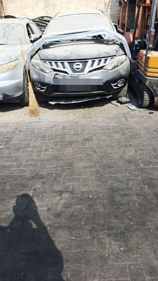 Dark grey Nissan Murano halfcut front: chrome grille, headlights, bumper and fog lights, Sharjah market