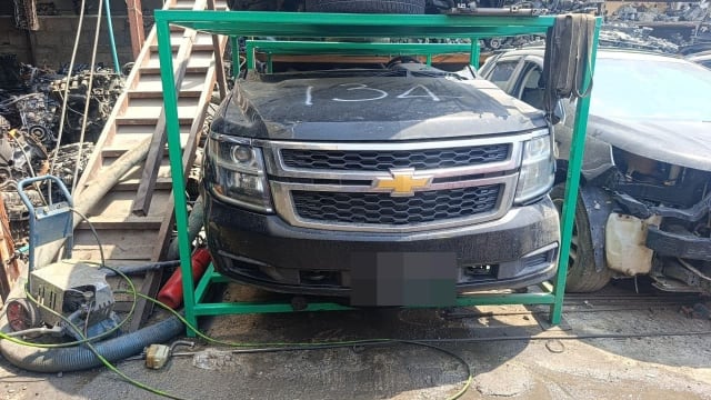 Black Chevrolet Tahoe front halfcut on stand with hood, chrome grille, headlights and bumper, Sharjah market