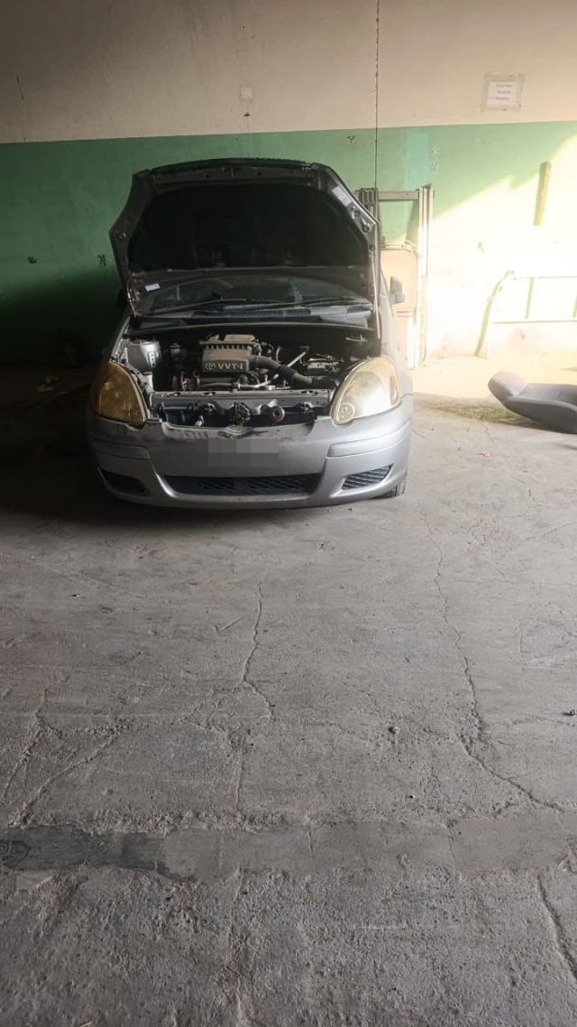 Silver Toyota Echo hatchback for parts, hood open showing VVT-i engine, headlights and bumper, Sharjah market