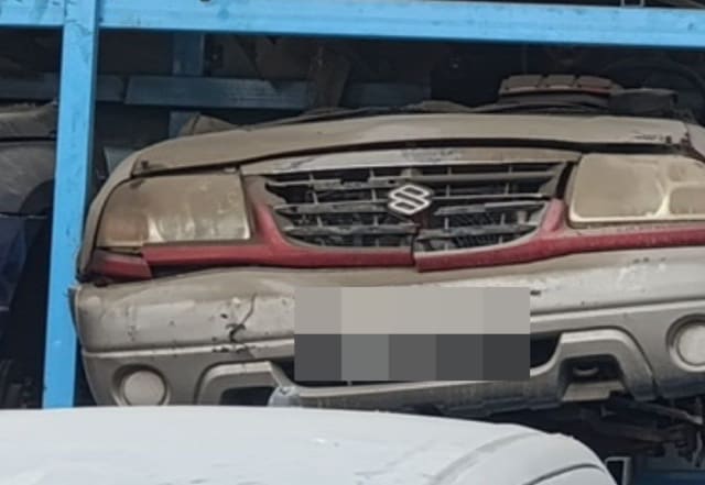 Beige Suzuki Grand Vitara front halfcut with bumper, grille, headlights and hood on a rack, Sharjah market