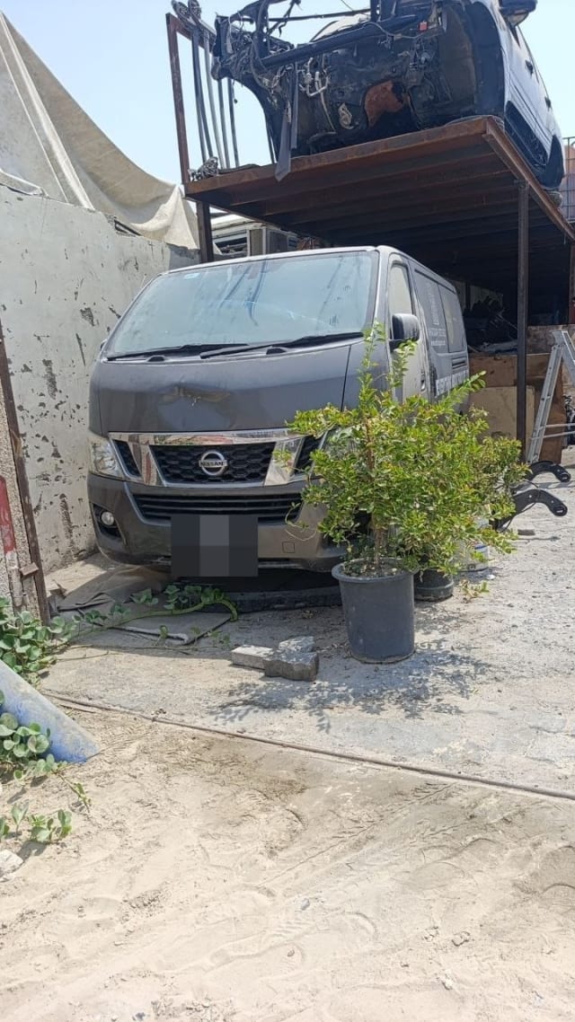 Grey Nissan NV350 Urvan van for parts with front bumper, chrome grille, headlights and hood, Sharjah market