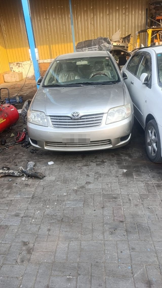 Silver Toyota Corolla sedan for parts, front view: bumper, grille, headlights and hood, Sharjah market