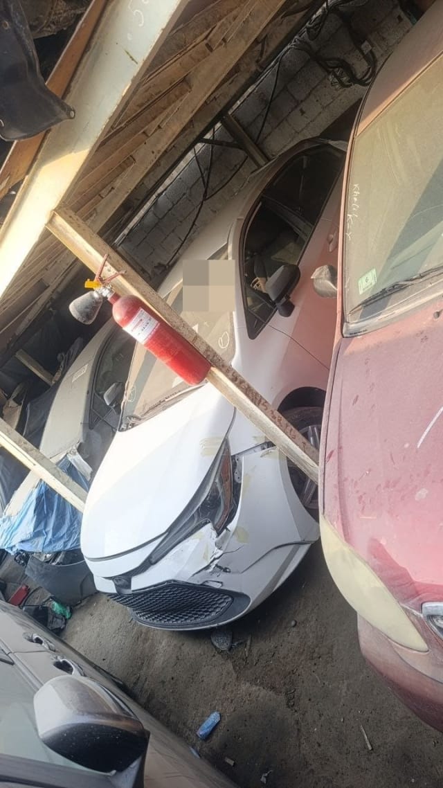 White Toyota Corolla halfcut front view — hood, damaged front bumper, headlight and fender, Sharjah market