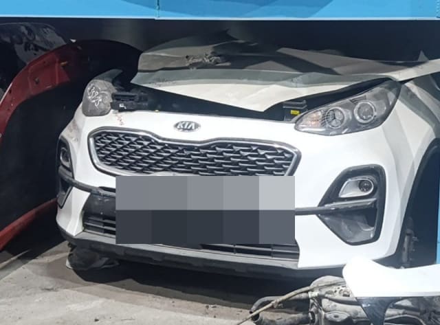 White Kia Sportage front halfcut: bumper, grille, headlights and creased hood, Sharjah market