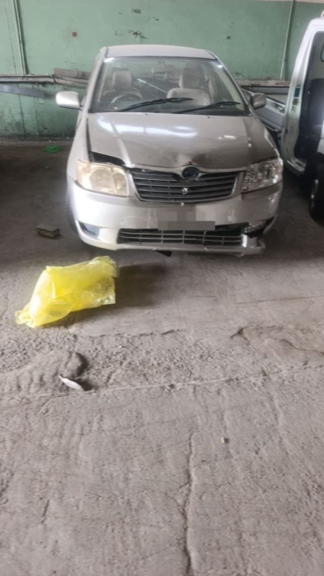 Silver Toyota Corolla sedan for parts, front view with hood, grille, headlights and damaged bumper, Sharjah market