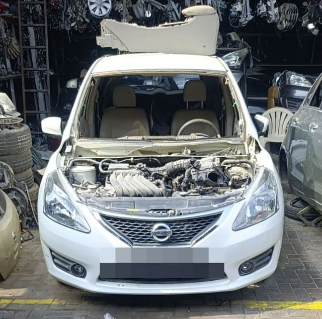 White Nissan Tiida hatchback front halfcut: engine bay, grille, bumper and headlights, Sharjah market