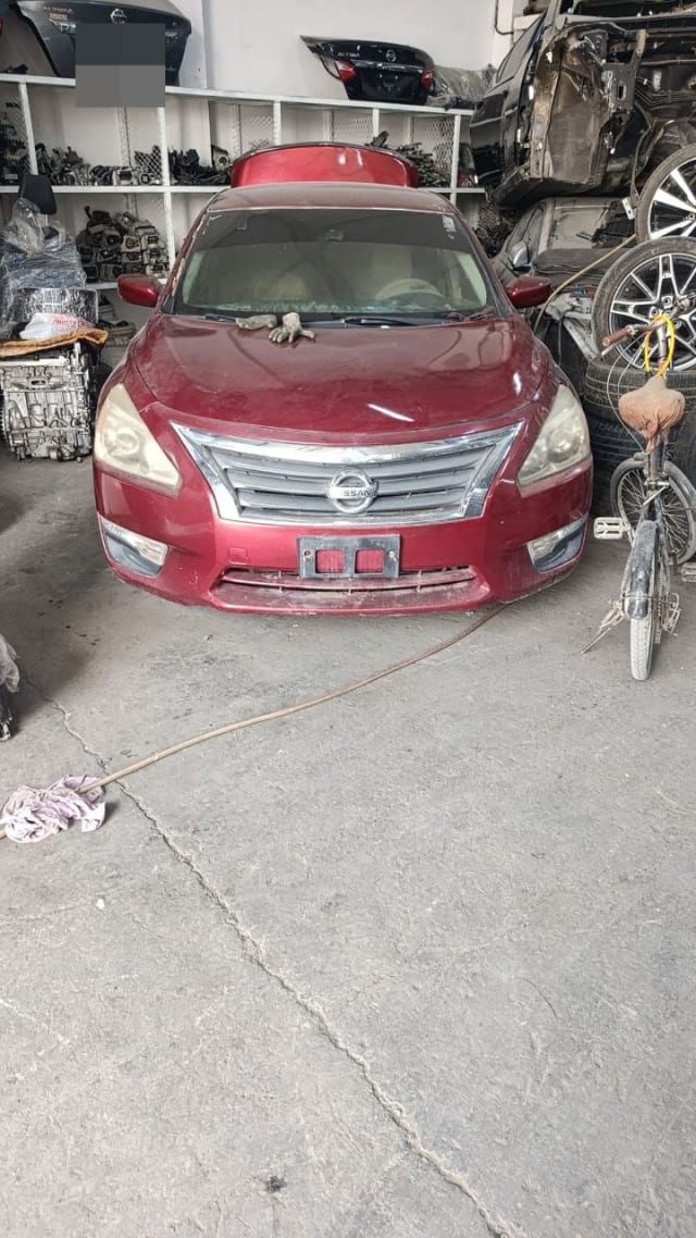 Dark red Nissan Altima sedan for parts — front bumper, chrome grille, headlights and hood, Sharjah market
