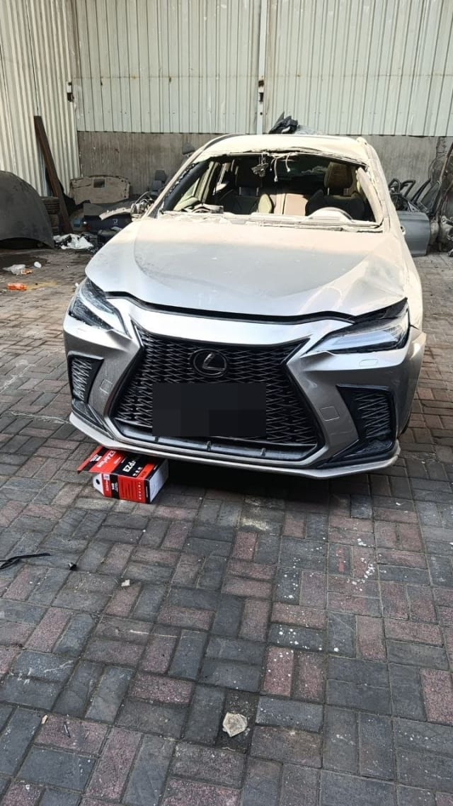 Silver Lexus NX halfcut front view: spindle grille, headlights, bumper and creased hood, Sharjah market