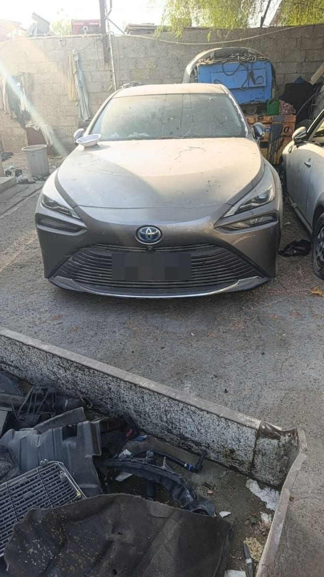 Dusty grey Toyota Mirai sedan halfcut front view — bumper, grille, headlights and hood, Sharjah market