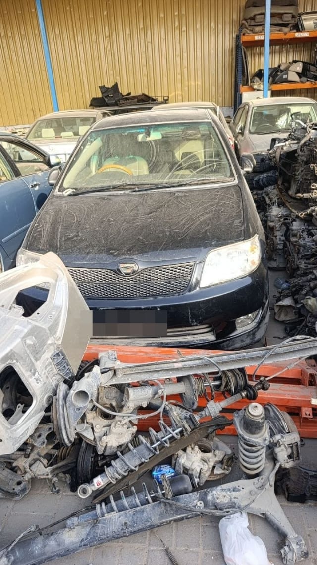 Black Toyota Corolla sedan halfcut front with grille and headlights, suspension parts in front, Sharjah market