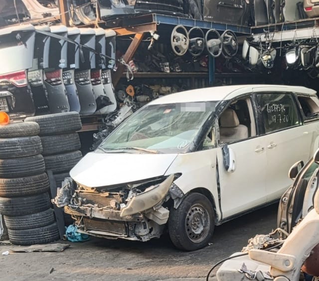 White Toyota Previa minivan halfcut, bumper off showing radiator, hood and headlight, Sharjah parts market