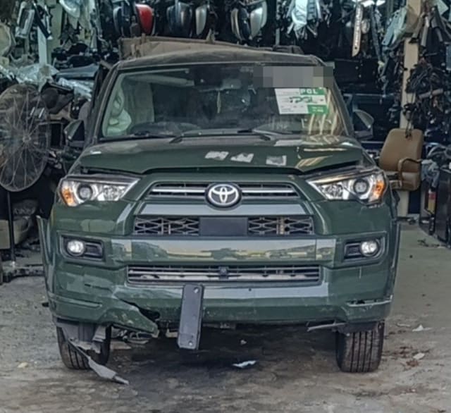 Dark green Toyota 4Runner halfcut front view — grille, headlights, hood and damaged bumper, Sharjah market