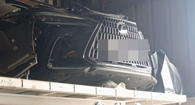 Dark grey Lexus GX460 front halfcut with spindle grille, bumper and headlights on a rack, Sharjah market