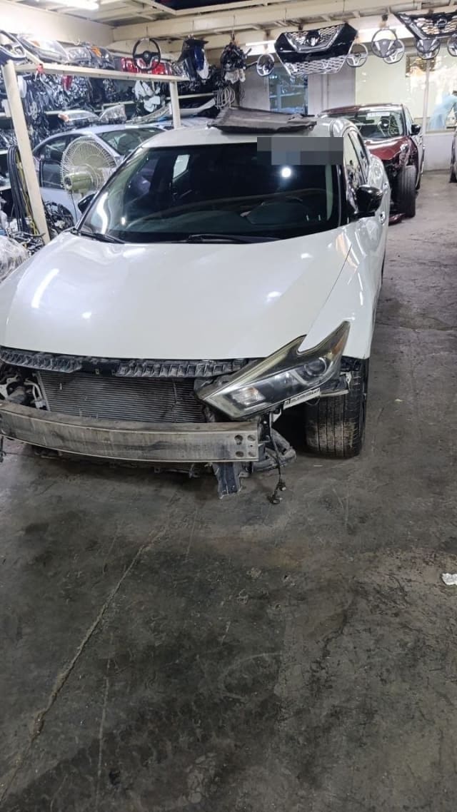 White Nissan Altima sedan halfcut, front view with hood, headlight, radiator and bumper beam, Sharjah market