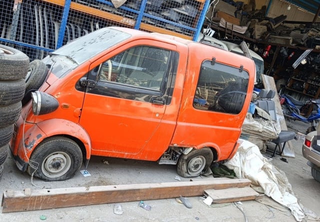 Orange Daihatsu Midget II microcar for parts, left side with headlight, door and wheels, Sharjah market
