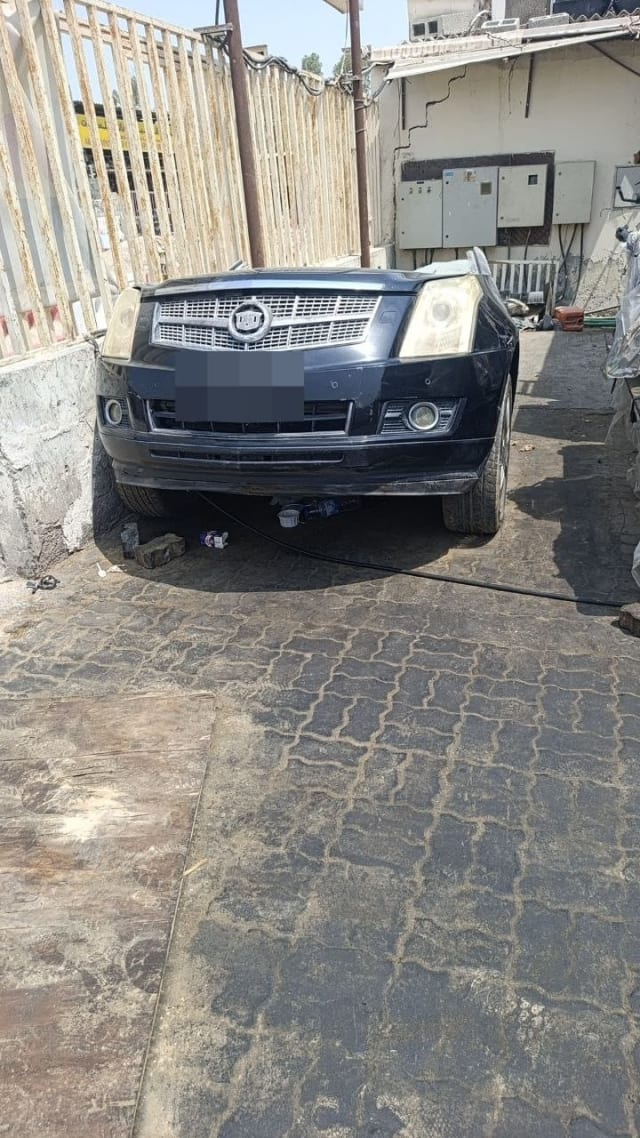 Dark blue Cadillac SRX front halfcut with chrome grille, headlights and bumper, Sharjah market