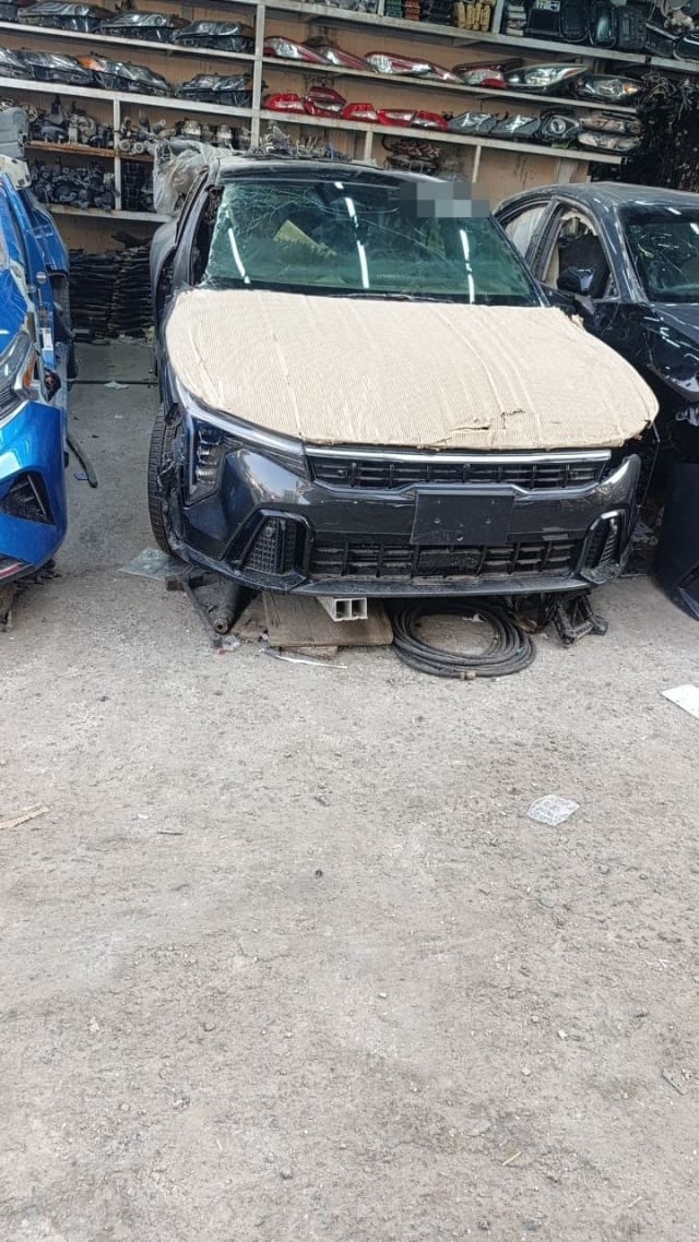 Dark navy Kia Sportage car for parts, front view: bumper, grille, headlights, cracked windshield, Sharjah market