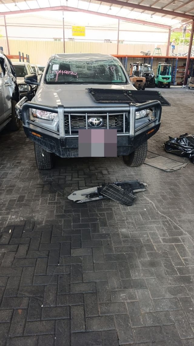 Silver Toyota Hilux pickup for parts — steel bull bar, grille, headlights, cracked windshield, Sharjah market