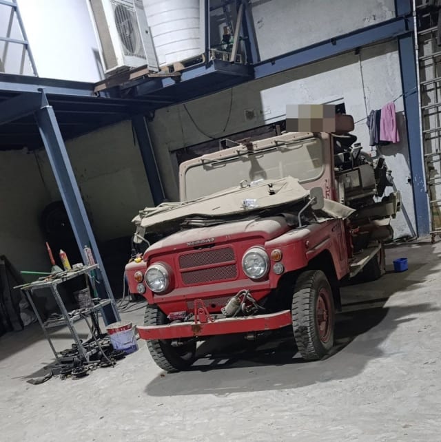 Red classic 4x4 for parts with bumper, mesh grille, round headlights and folded soft top, Sharjah market