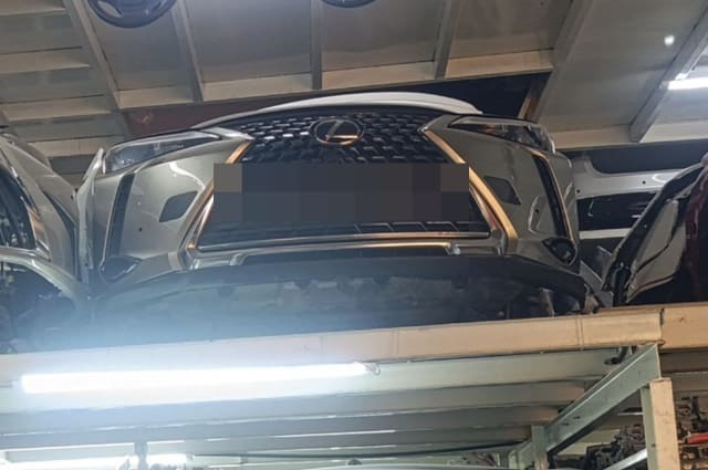 Silver Lexus NX front cut on rack, spindle grille, bumper and headlights, Sharjah market