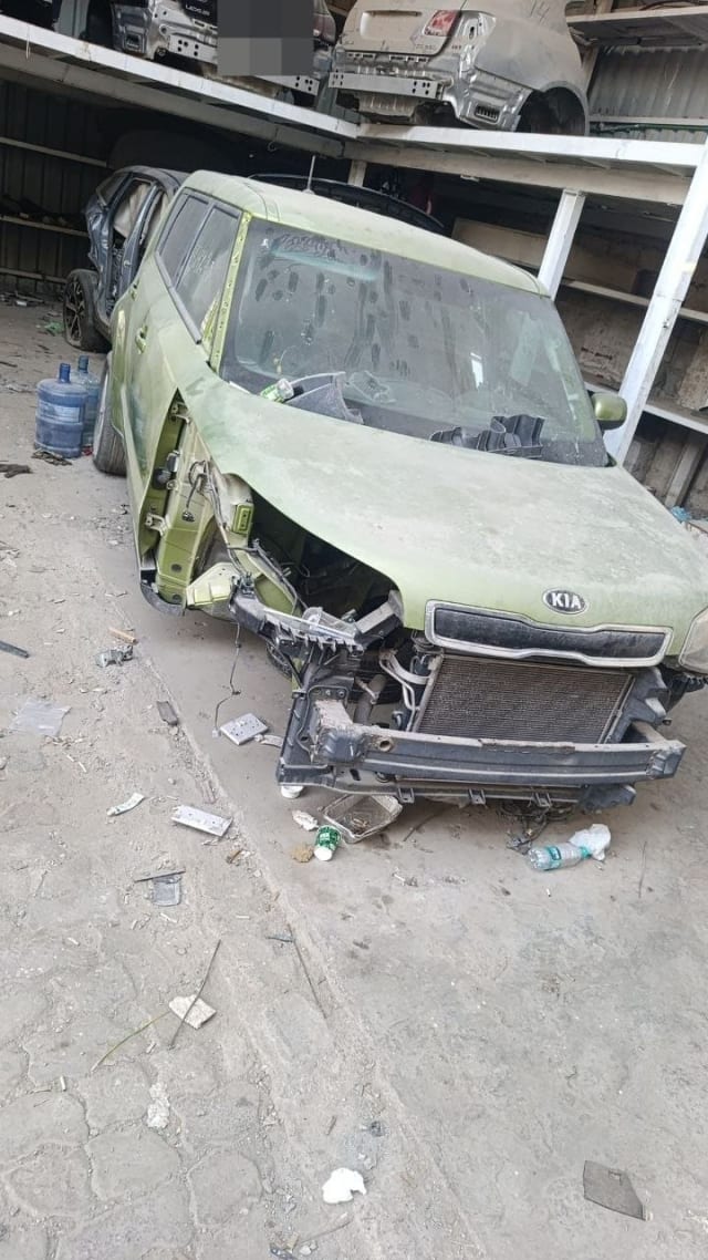 Green Kia Soul for parts, front bumper and left fender removed, hood, grille and radiator visible, Sharjah