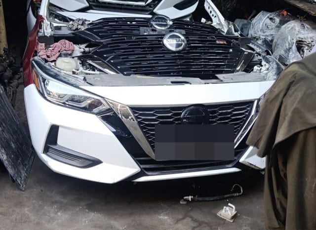 White Nissan Sentra front halfcut — bumper, chrome V grille and LED headlight, Sharjah market