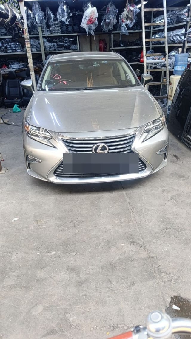 Silver Lexus ES sedan halfcut front view: spindle grille, LED headlights, hood and bumper, Sharjah market