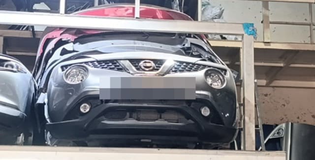 Grey Nissan Juke front halfcut — bumper, grille, round headlights and fog lights on a rack, Sharjah market