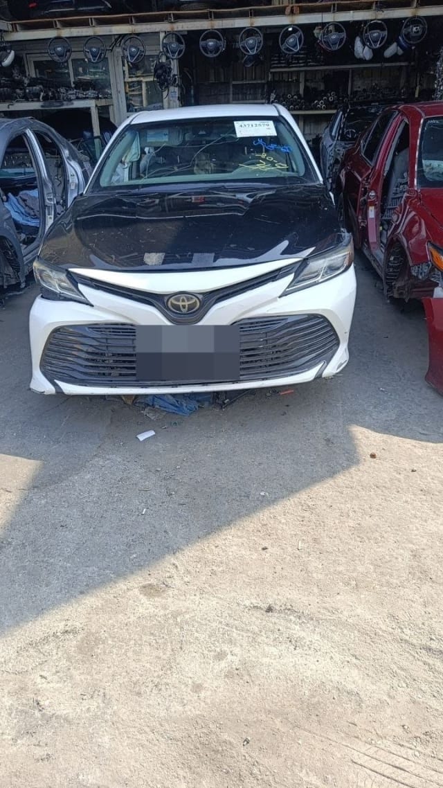 White Toyota Camry halfcut front view — bumper, grille, headlights and dark hood, Sharjah market