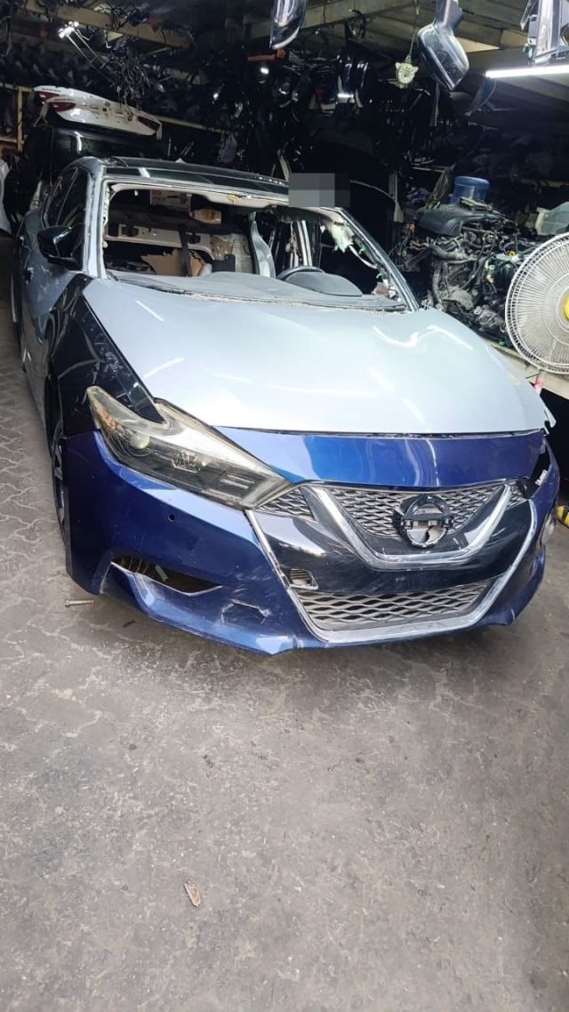 Blue Nissan Maxima sedan for parts with silver hood, grille, headlights and bumper, Sharjah market
