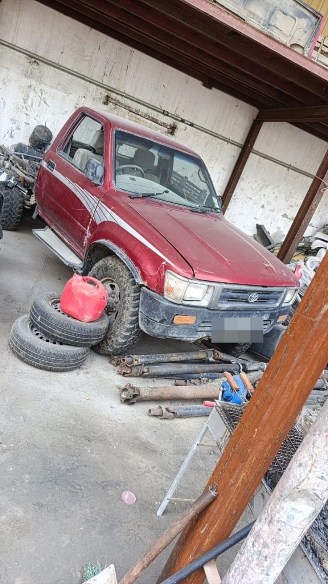 Red Toyota Hilux single cab pickup for parts — hood, grille, headlights and bumper, Sharjah market