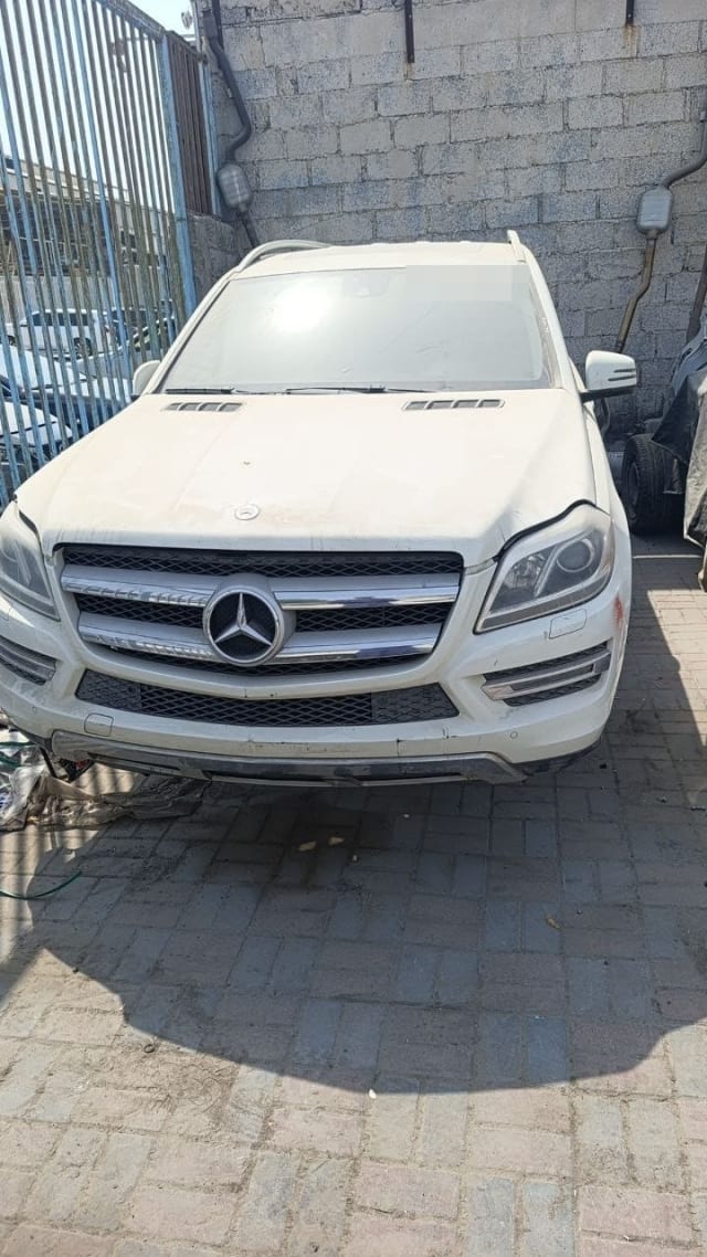 White Mercedes-Benz GL-Class SUV for parts, front view: hood, grille, bumper and headlights, Sharjah market