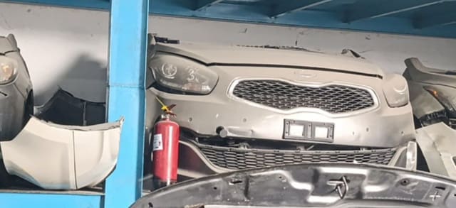 Grey Kia Cadenza front halfcut on shelf: bumper, grille and headlights, Sharjah market