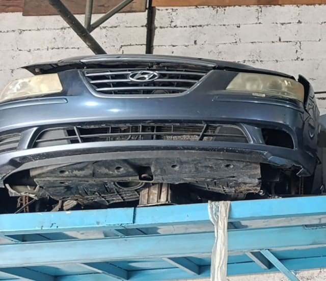 Dark blue-grey Hyundai Sonata front halfcut with bumper, chrome grille and headlights on rack, Sharjah market