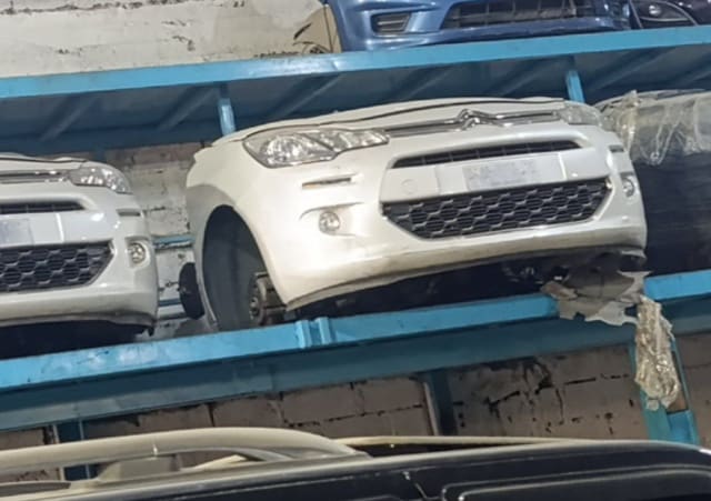 White Citroen C3 front halfcut on rack, bumper, headlights, grille and fog lights, Sharjah market