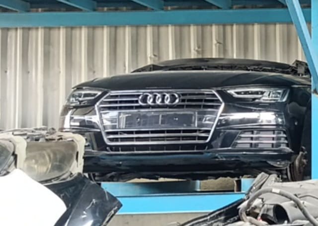 Black Audi A4 front halfcut on rack — chrome grille, LED headlights, hood and bumper, Sharjah market