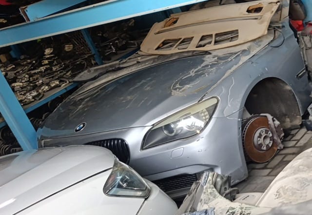 Silver BMW 7-Series front halfcut showing hood, kidney grille, headlight, fender and brake disc, Sharjah market