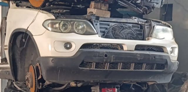 White BMW X5 SUV halfcut front: bumper, headlights, cooling fan and brake disc, Sharjah market