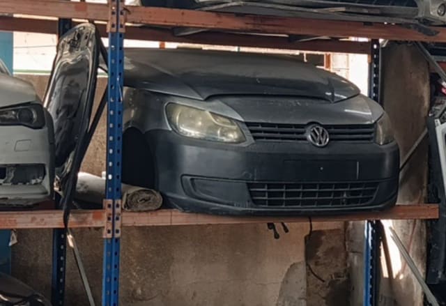 Dark grey Volkswagen Caddy front halfcut on a rack — hood, headlights, grille and bumper, Sharjah market