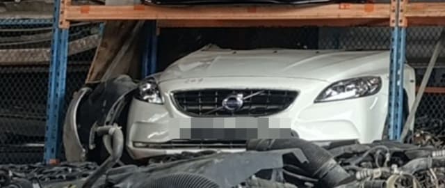 White Volvo V40 front halfcut on rack — bumper, grille, headlights and hood, Sharjah market