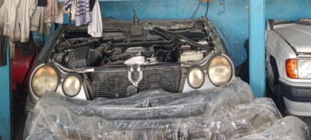 Silver Mercedes-Benz E-Class halfcut, quad headlights, open engine bay and radiator, Sharjah market