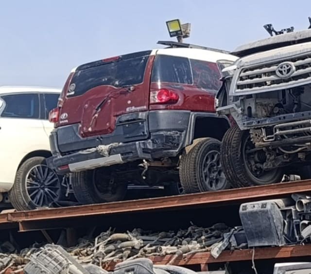 Dark red Toyota FJ Cruiser for parts, rear view — rear door, tail lights and damaged bumper, Sharjah market